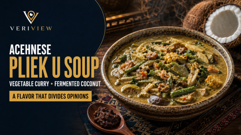 Semangkuk kuah pliek u Aceh berkuah kuning berisi kacang panjang, nangka muda, terung, jagung, dan udang, disajikan dengan sesendok sambal dan kelapa di sisi meja