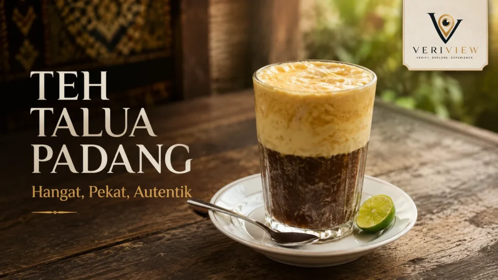 Segelas teh talua Padang dengan busa telur tebal, teh pekat di bawahnya, dan sepotong jeruk nipis di piring saji