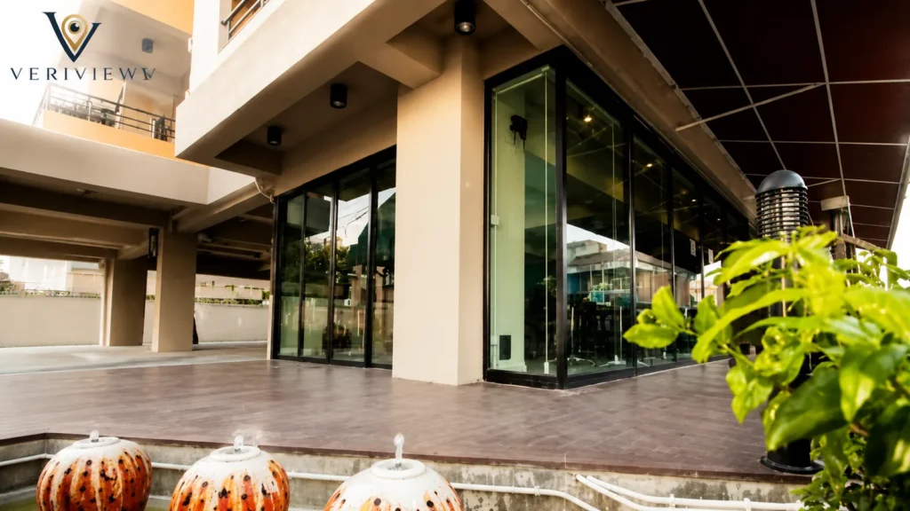 Bagian depan W Sotel Hotel Songkhla dengan area teras berlantai kayu dan dinding kaca